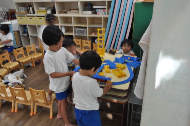 年長のお兄さんがプラレールを組むのを手伝ってくれています